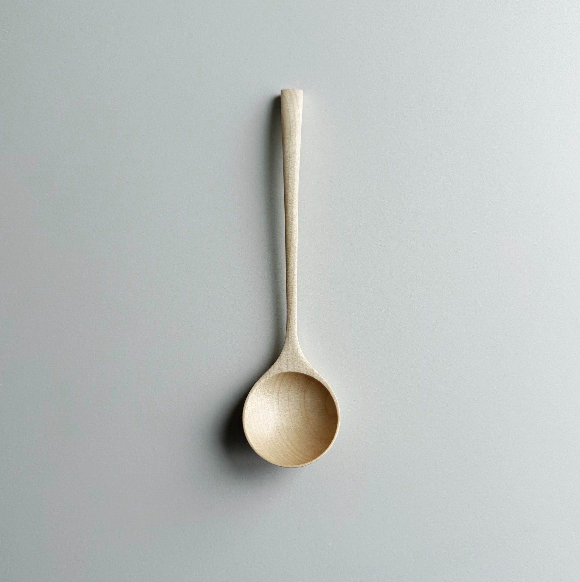 Angled eating spoon in sycamore on a light background