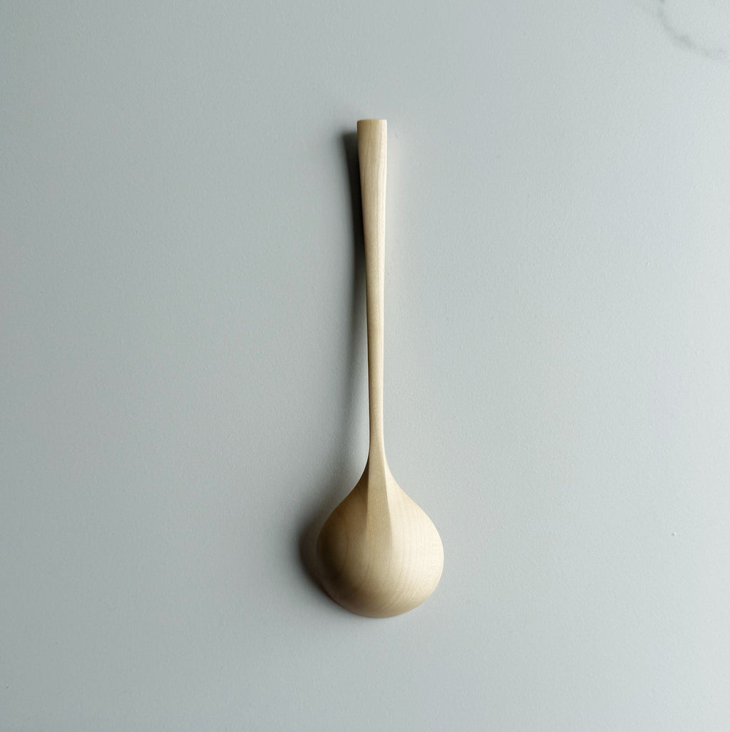 Angled eating spoon in sycamore on a light background