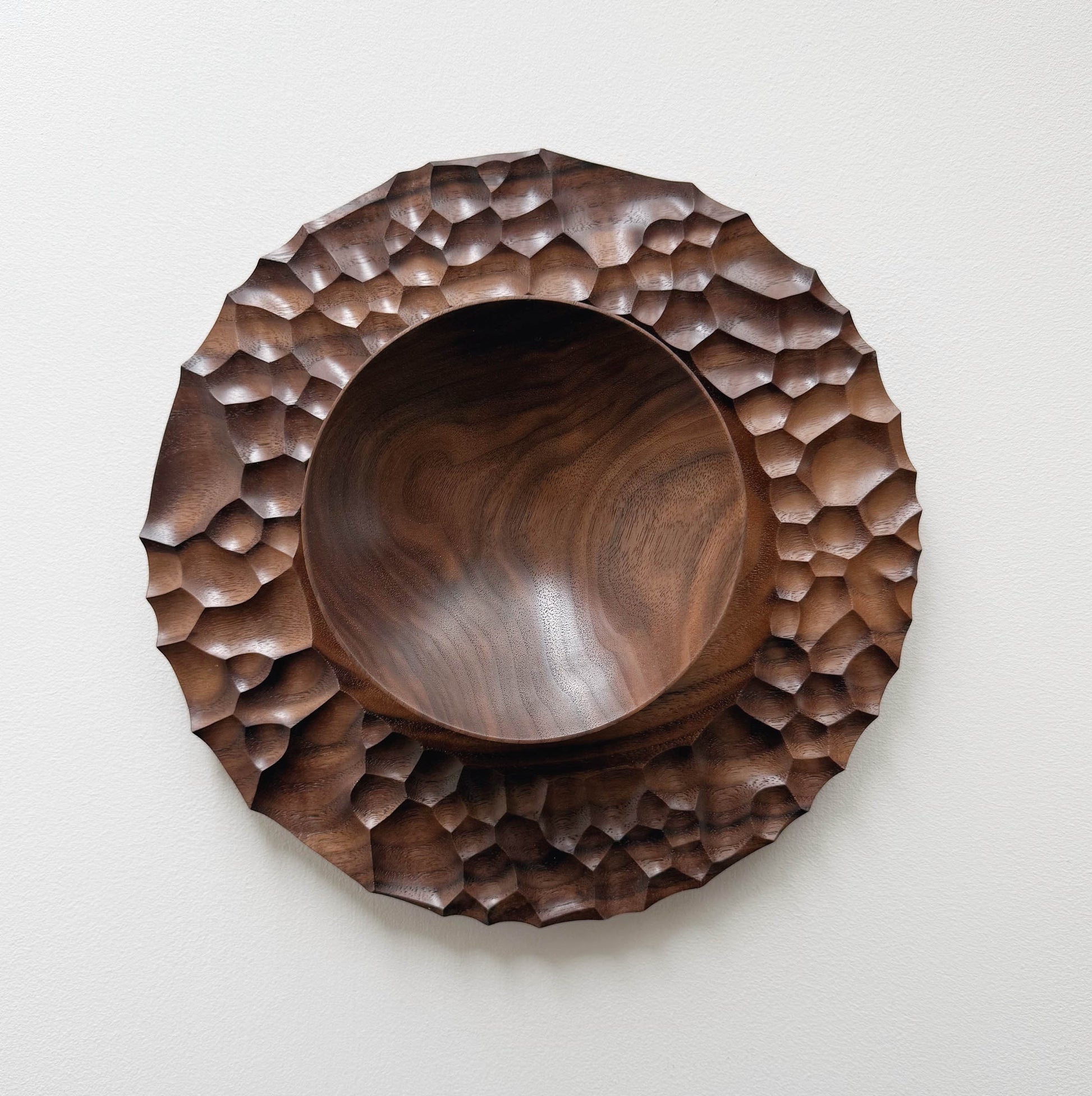 Biome plate and round palm bowl in tanned walnut on a light background