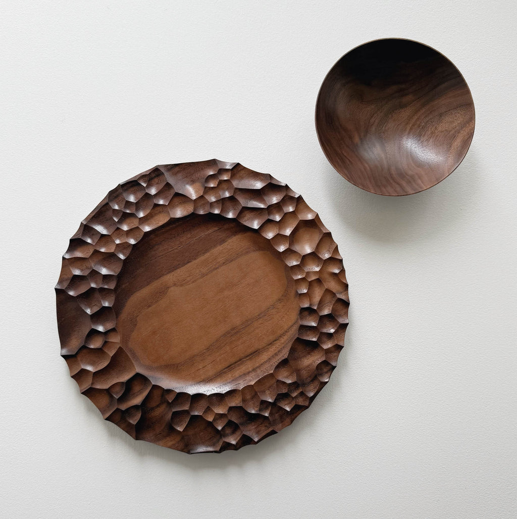 Biome plate and round palm bowl in tanned walnut on a light background