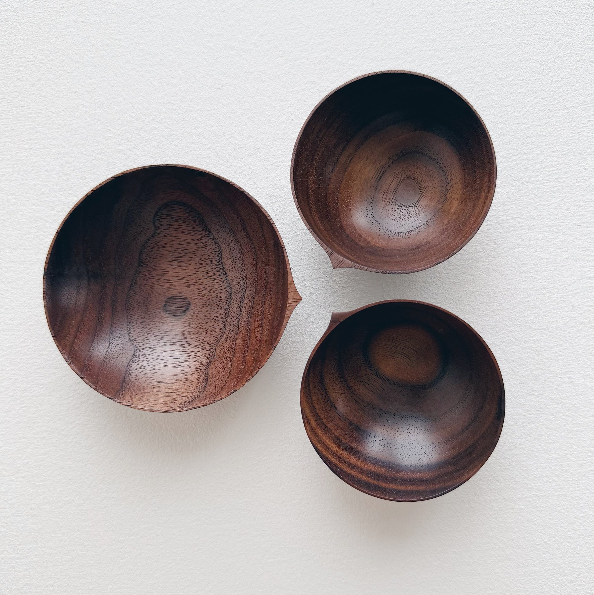 Set of walnut bowls and chopsticks on a white background