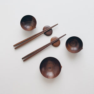 Set of walnut bowls and chopsticks on a white background