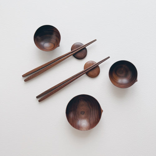 Set of walnut bowls and chopsticks on a white background