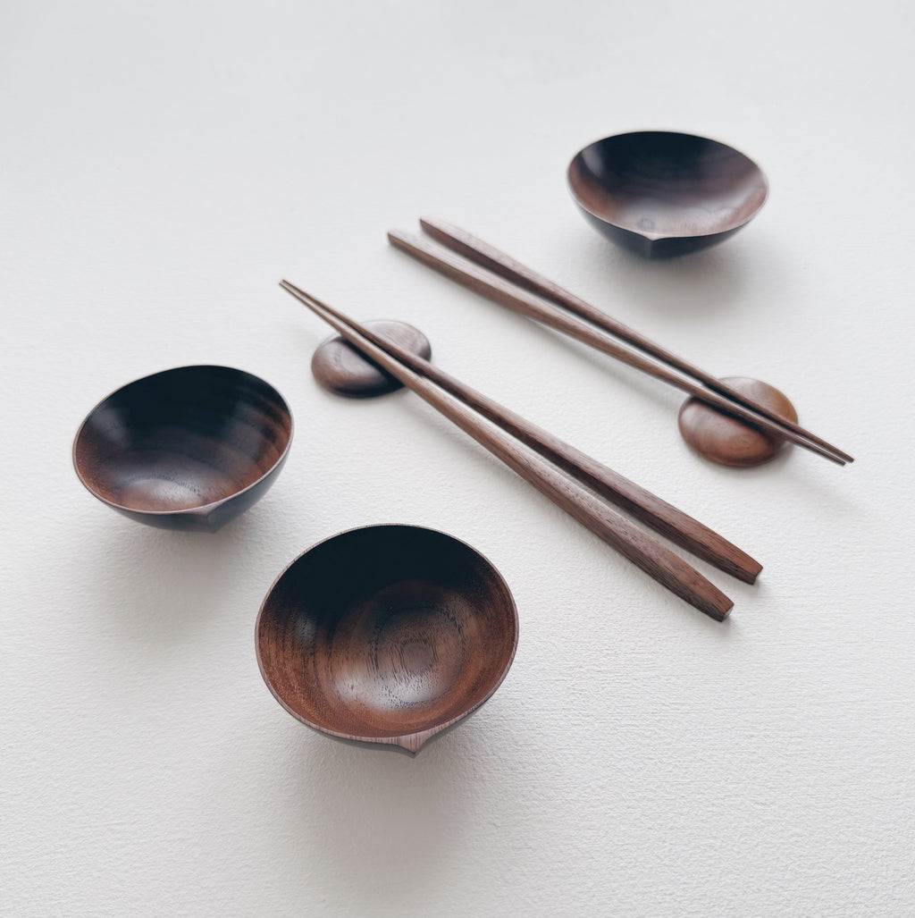 Set of walnut bowls and chopsticks on a white background