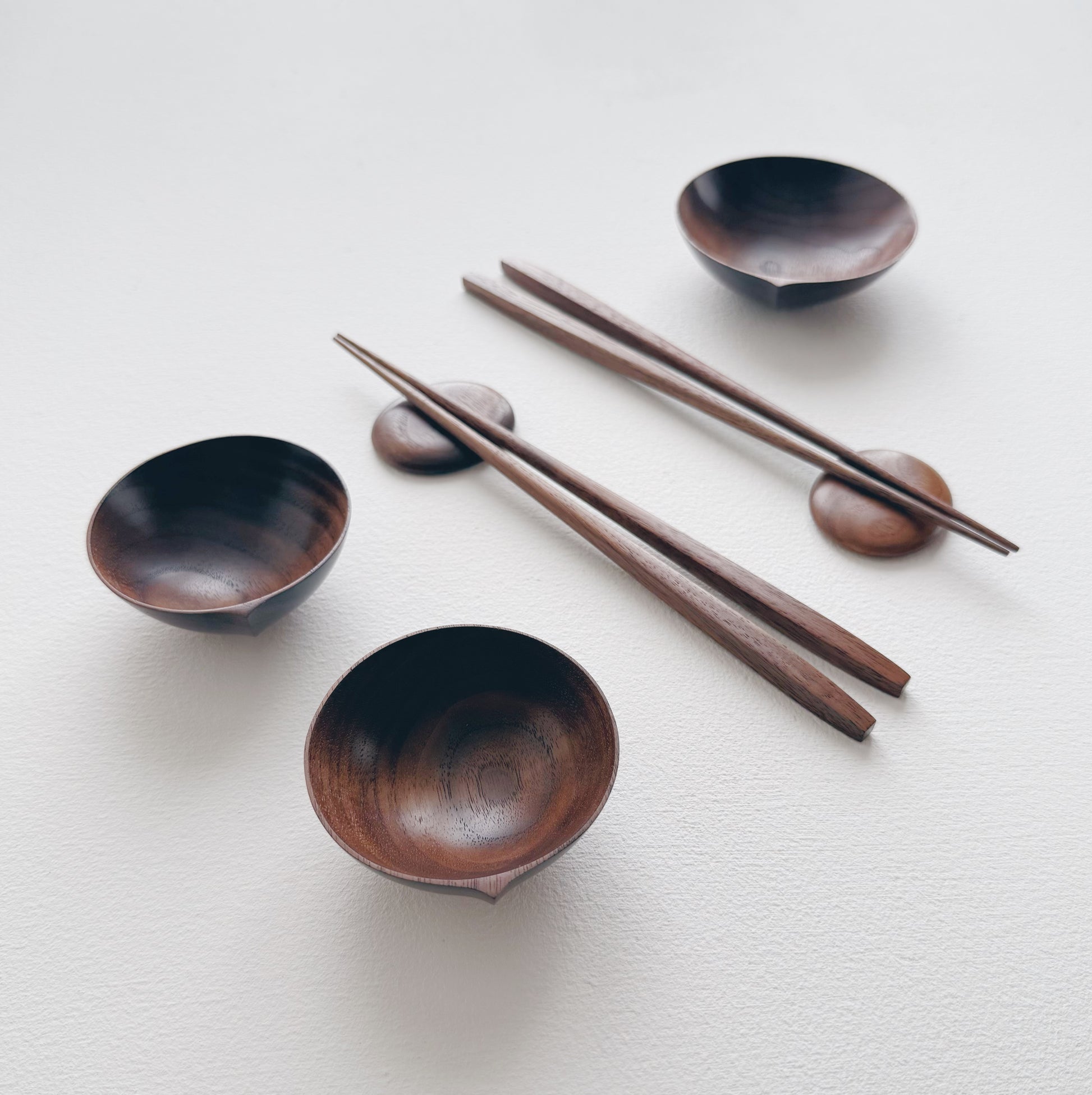 Set of walnut bowls and chopsticks on a white background
