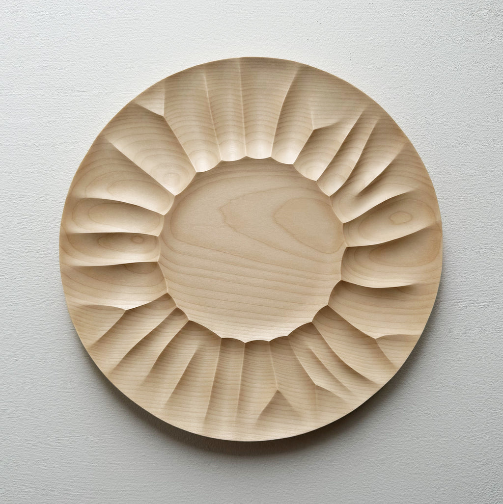 Sycamore wooden plate with a sculptural design on a white background