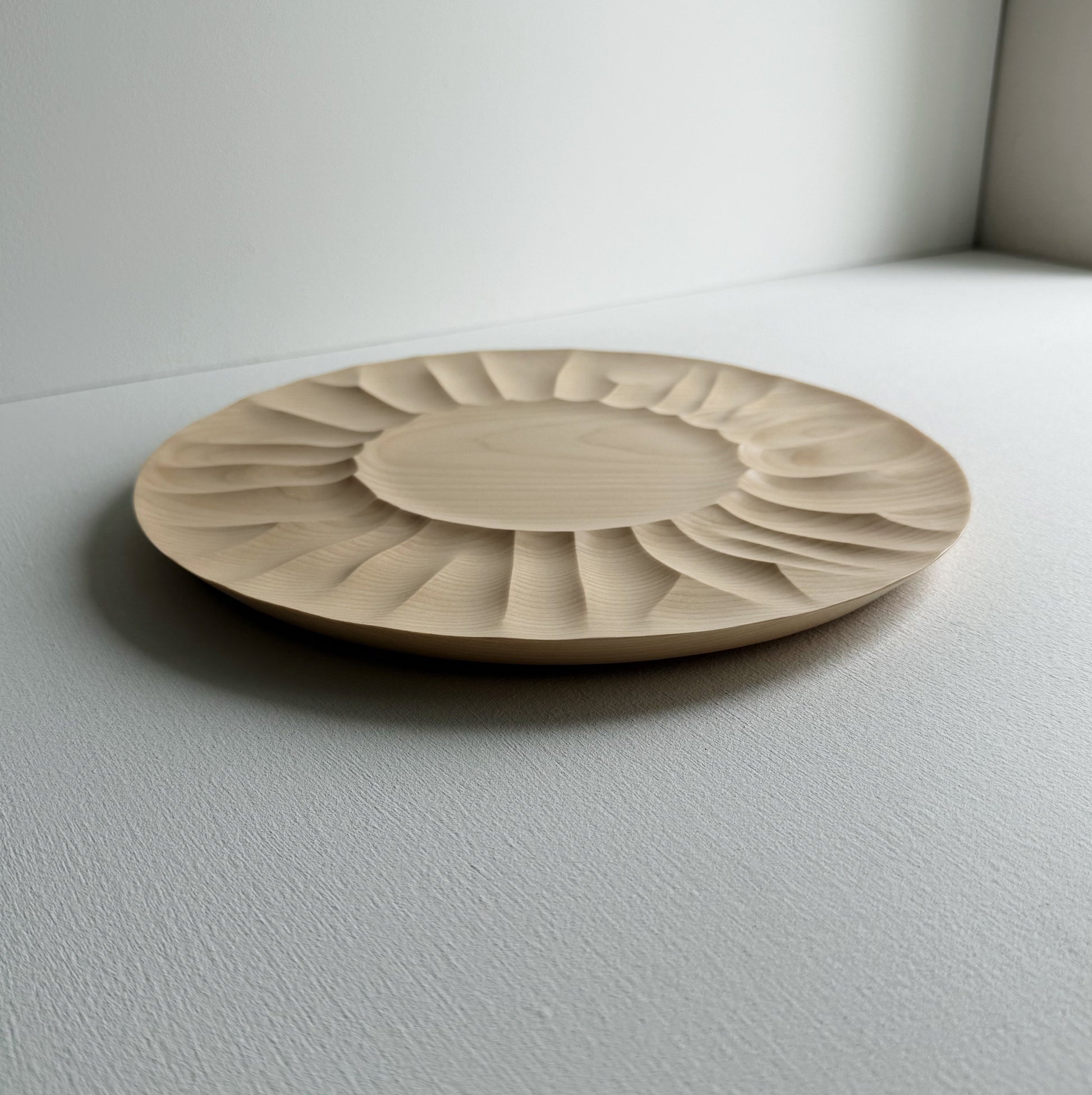 Sycamore wooden plate with a sculptural design on a white background