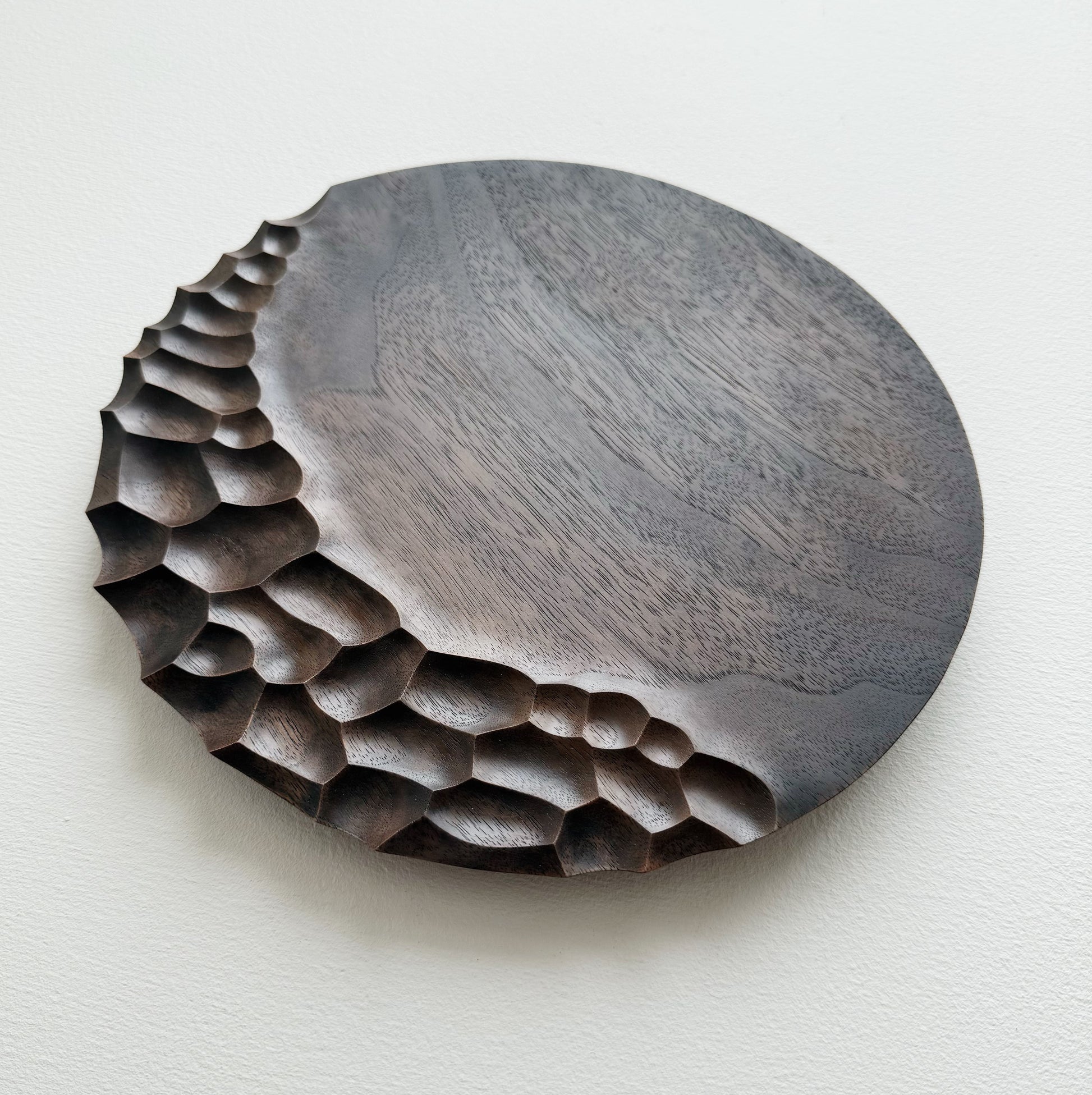 Black walnut coast plate with cratered edge on white background