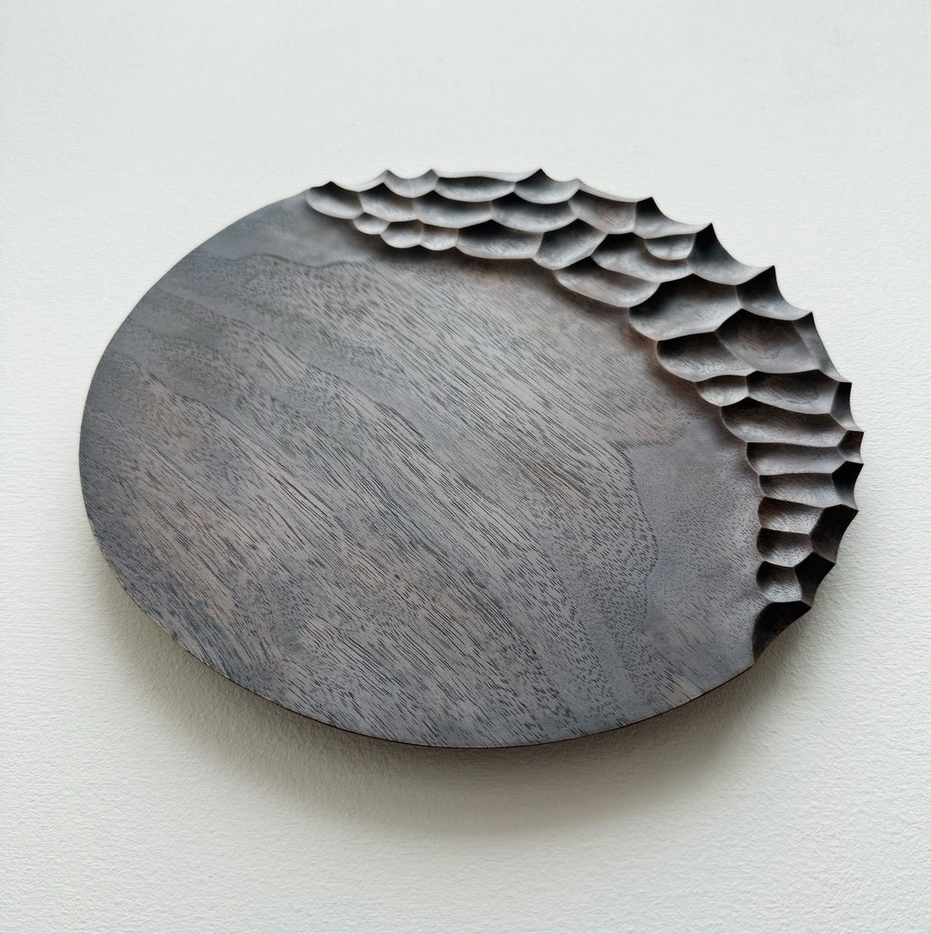 Black walnut coast plate with cratered edge on white background