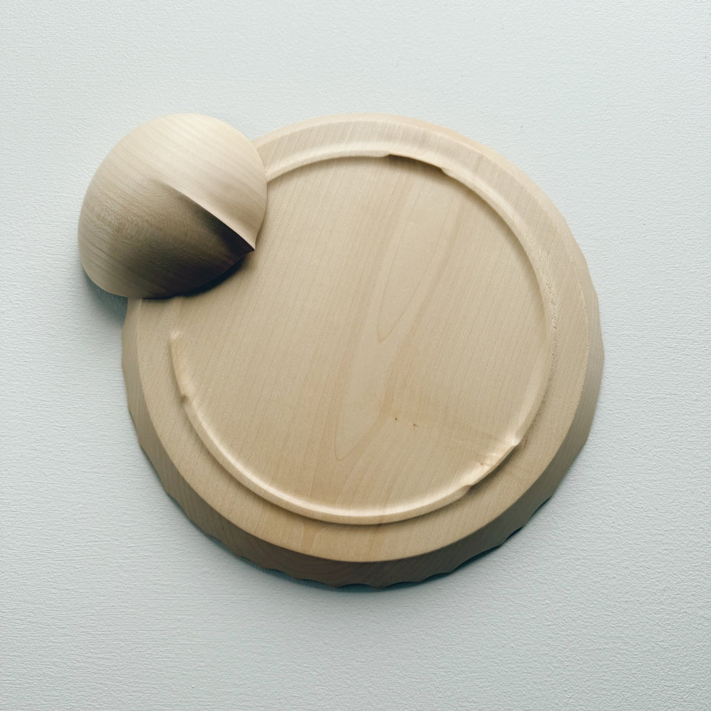 Underneath of sycamore bowl and plate set with sculptural design on a white background