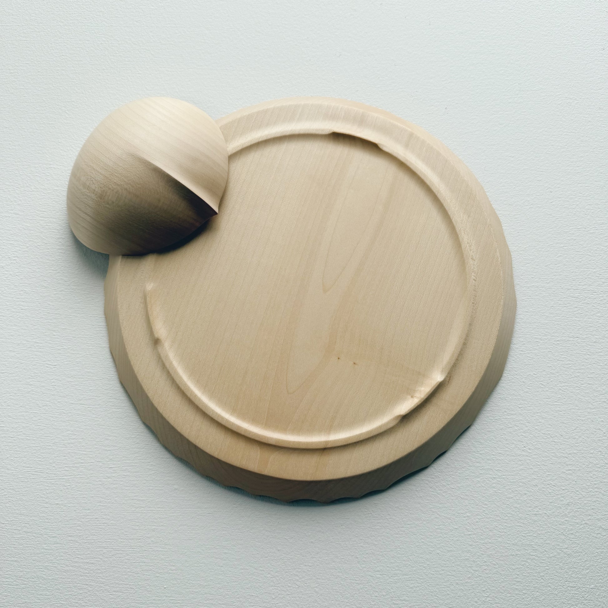 Underneath of sycamore bowl and plate set with sculptural design on a white background