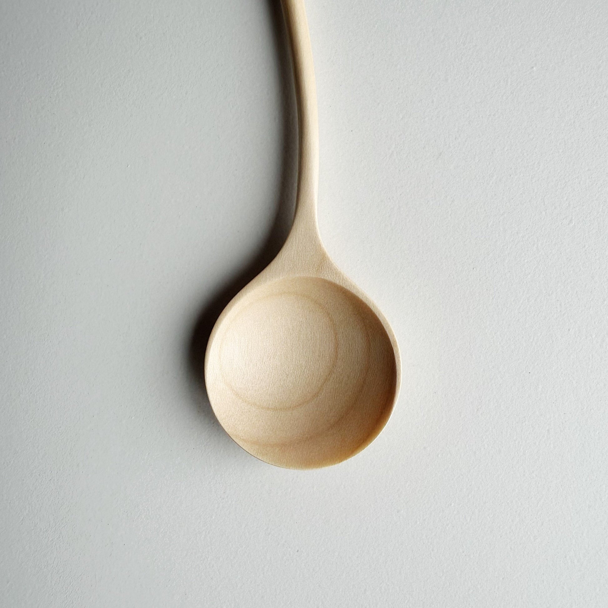 Sycamore curvy spoon on a light background