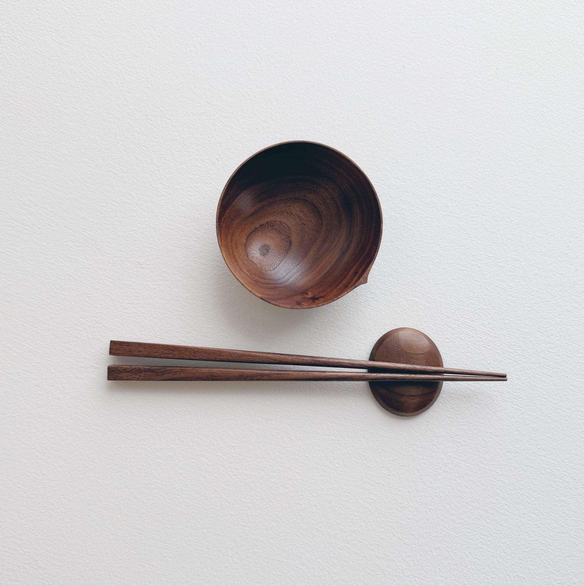 Walnut bowl and chopsticks on a white background