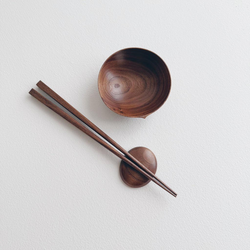 Walnut bowl and chopsticks on a white background