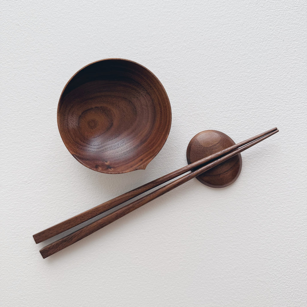Walnut bowl and chopsticks on a white background