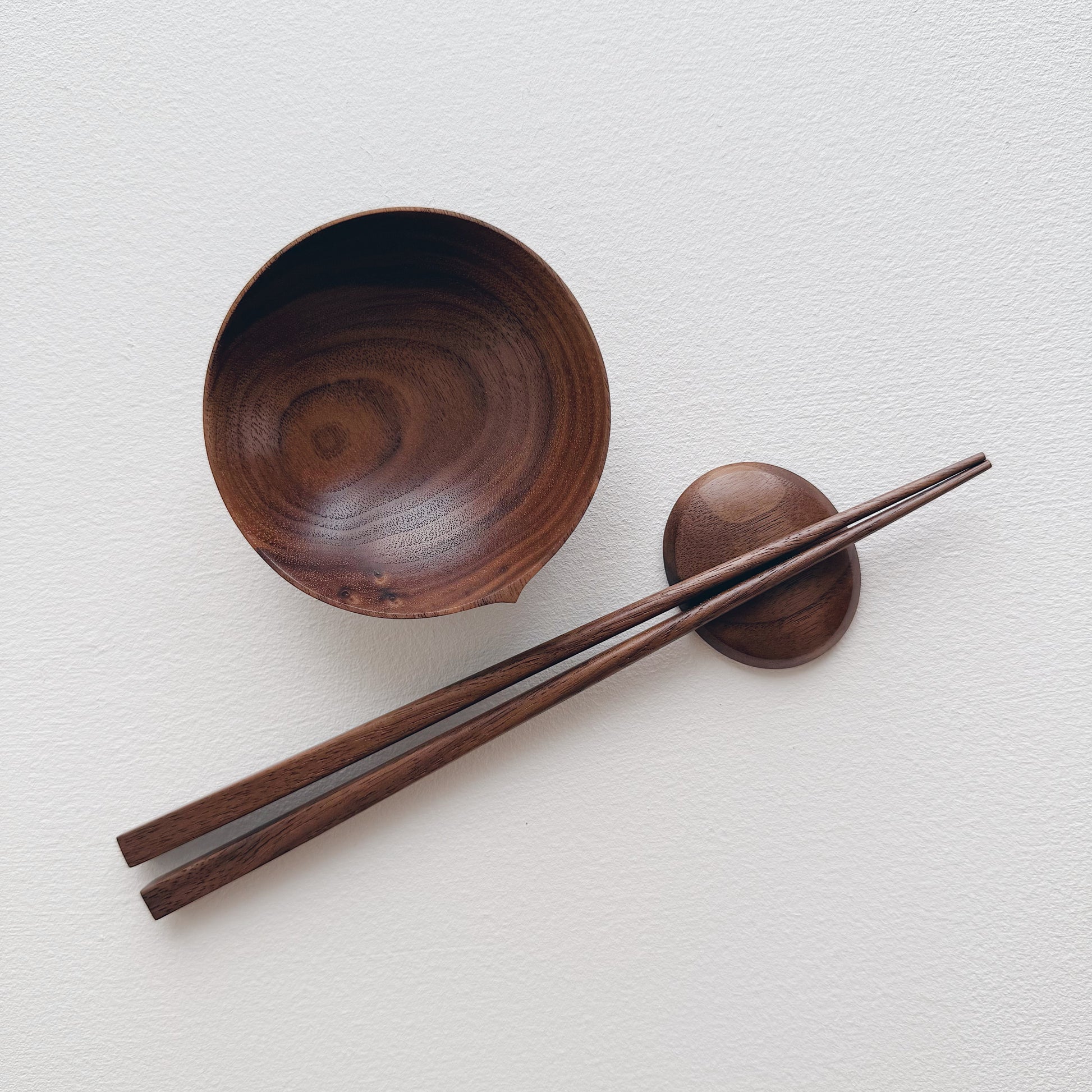 Walnut bowl and chopsticks on a white background