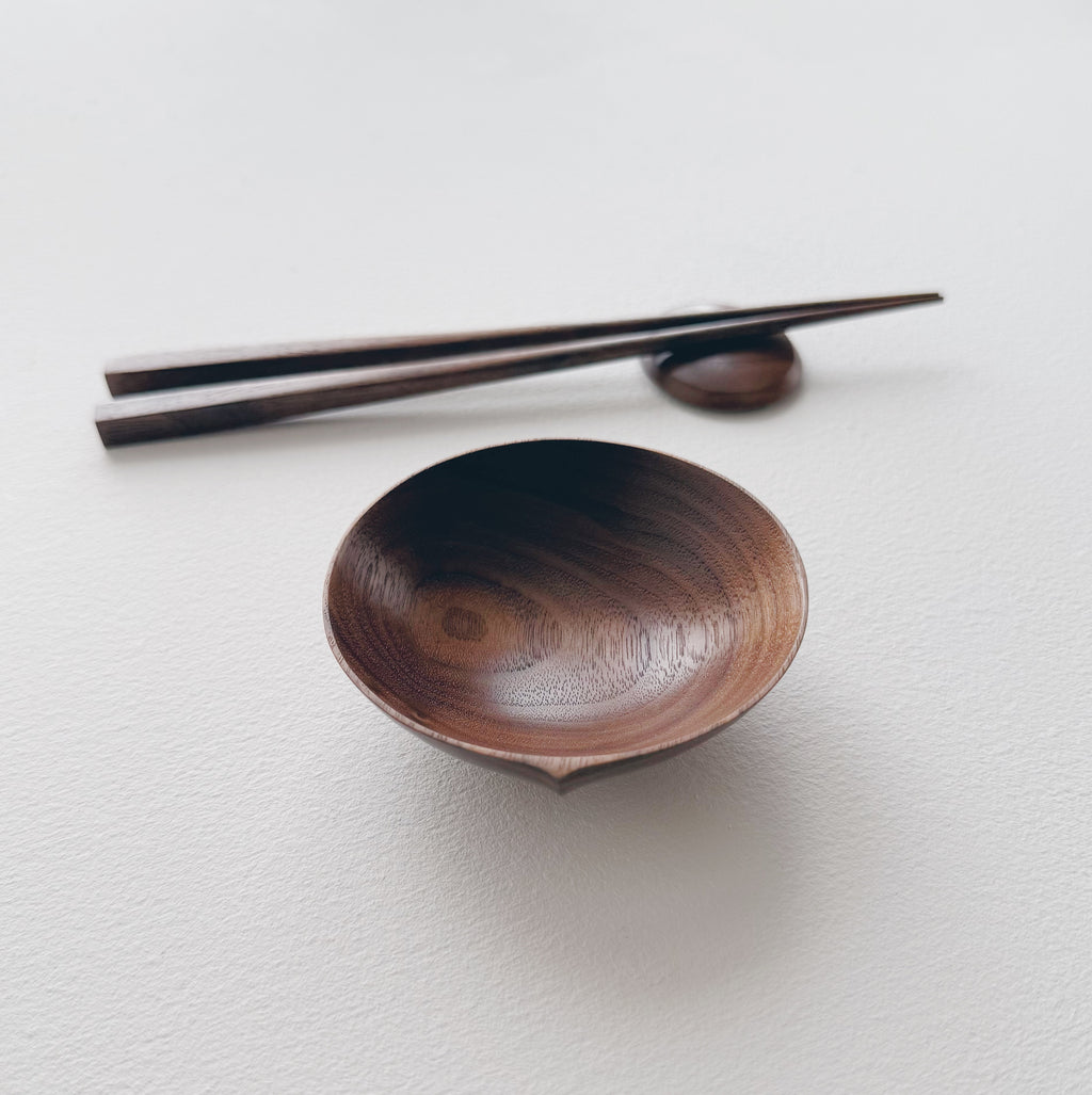 Walnut bowl and chopsticks on a white background