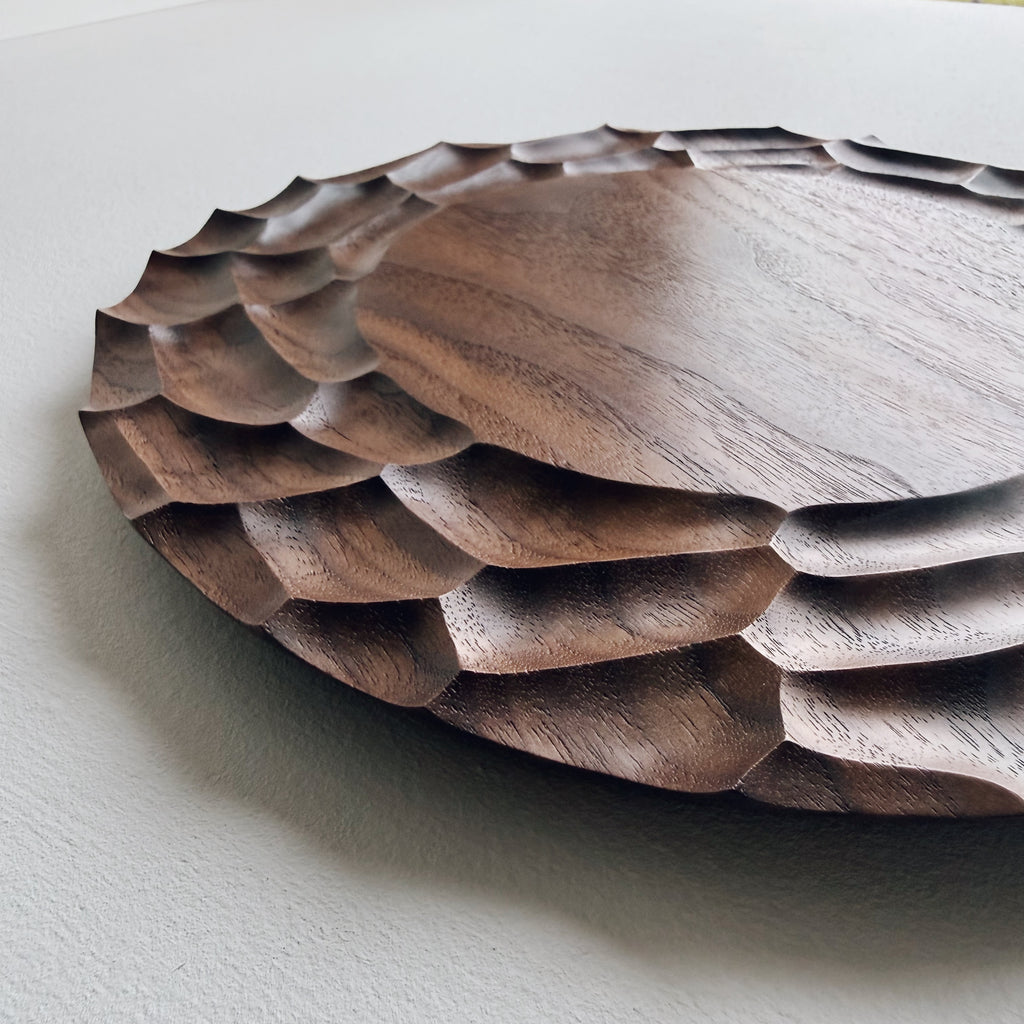 Close up of walnut Dunes plate on a white background