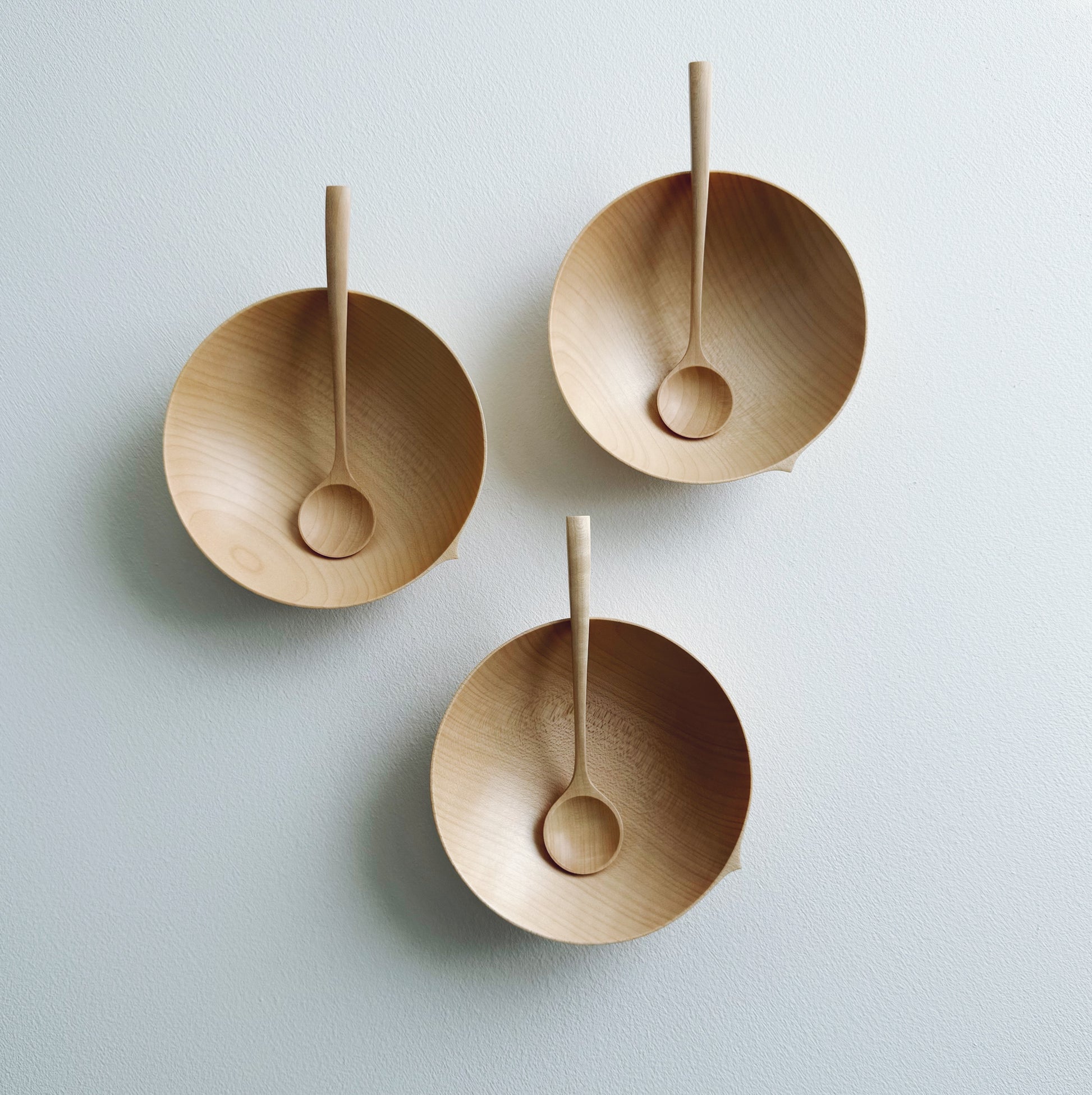 Eating bowl in sycamore with angled eating spoon on a white background
