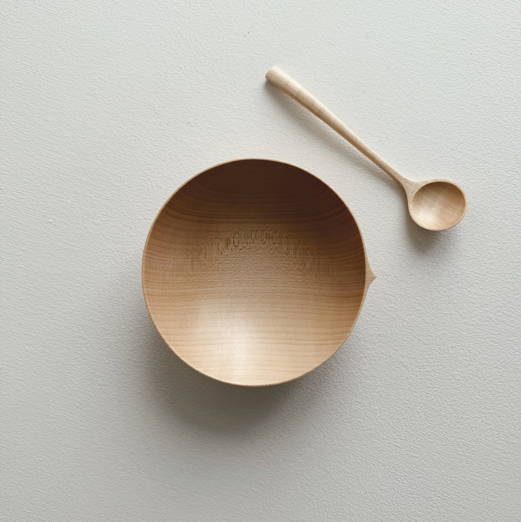 Eating bowl in sycamore with angled eating spoon on a white background

