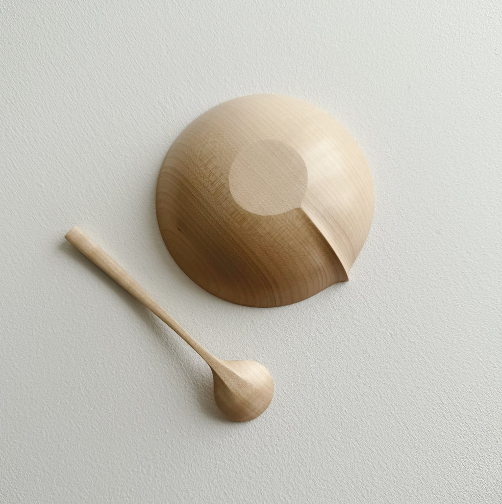Eating bowl in sycamore with angled eating spoon on a white background
