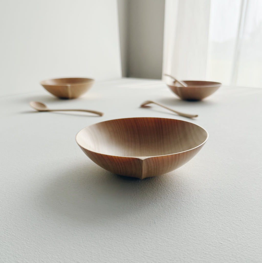 Eating bowl in sycamore with angled eating spoon on a white background
