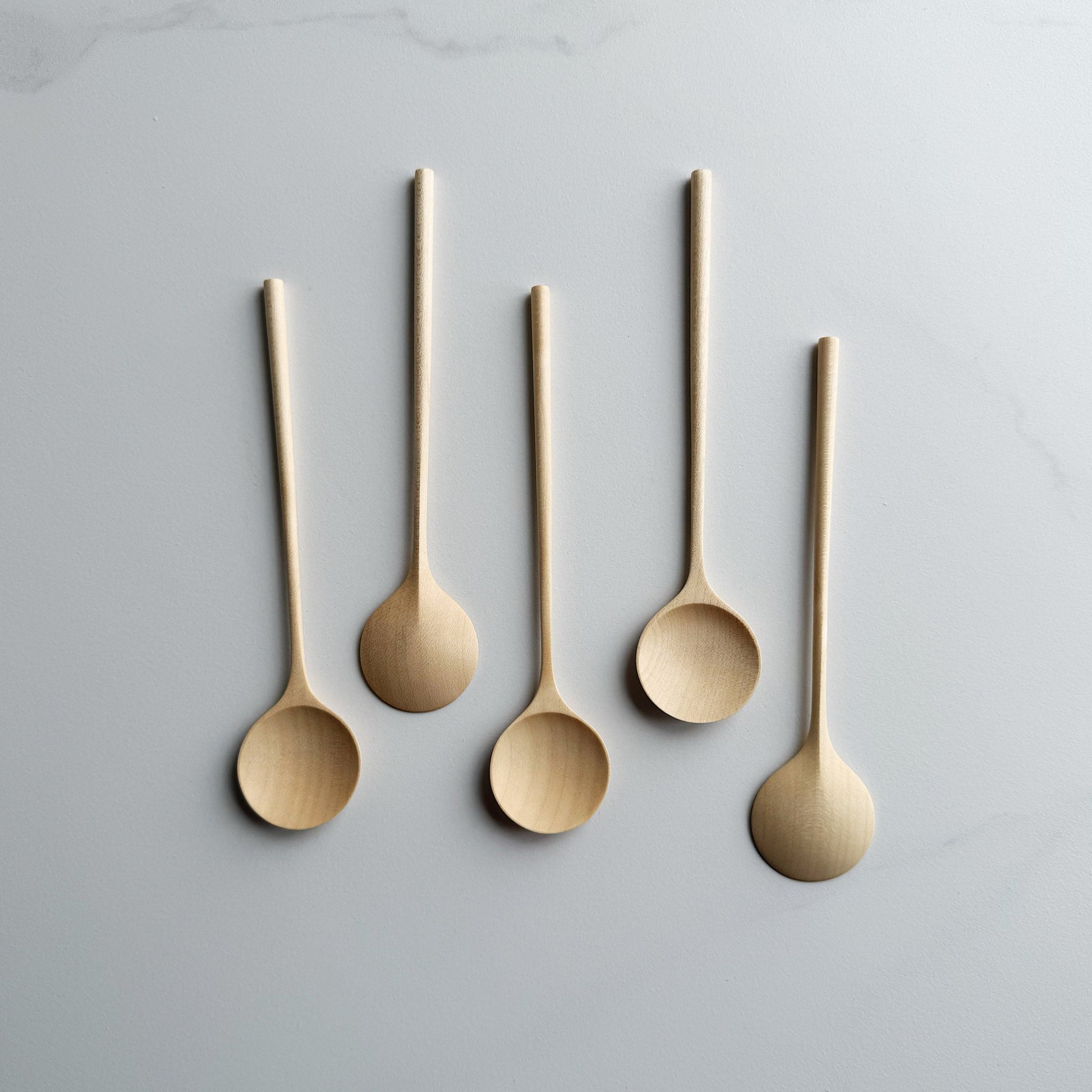 Sycamore eating spoons on light background
