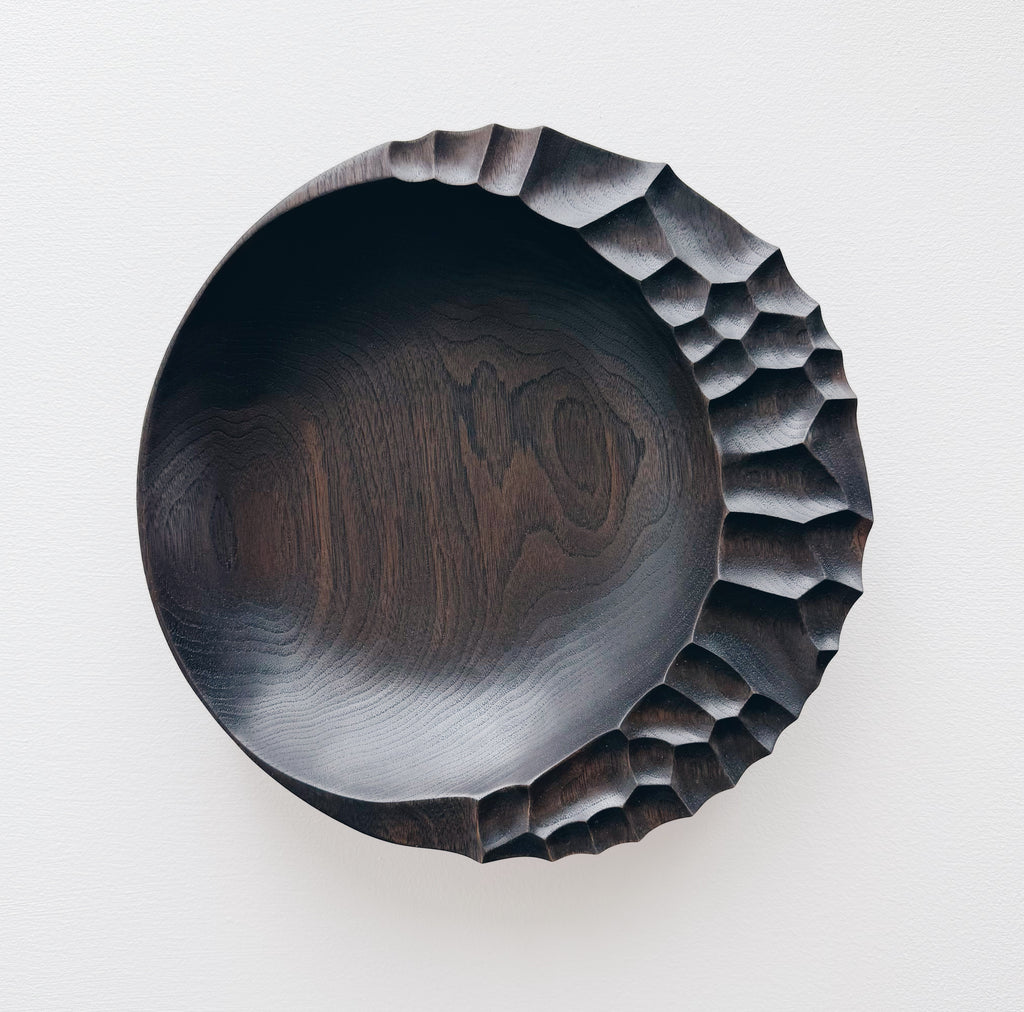 Ebonised walnut presentation board with sculptural design on a white background