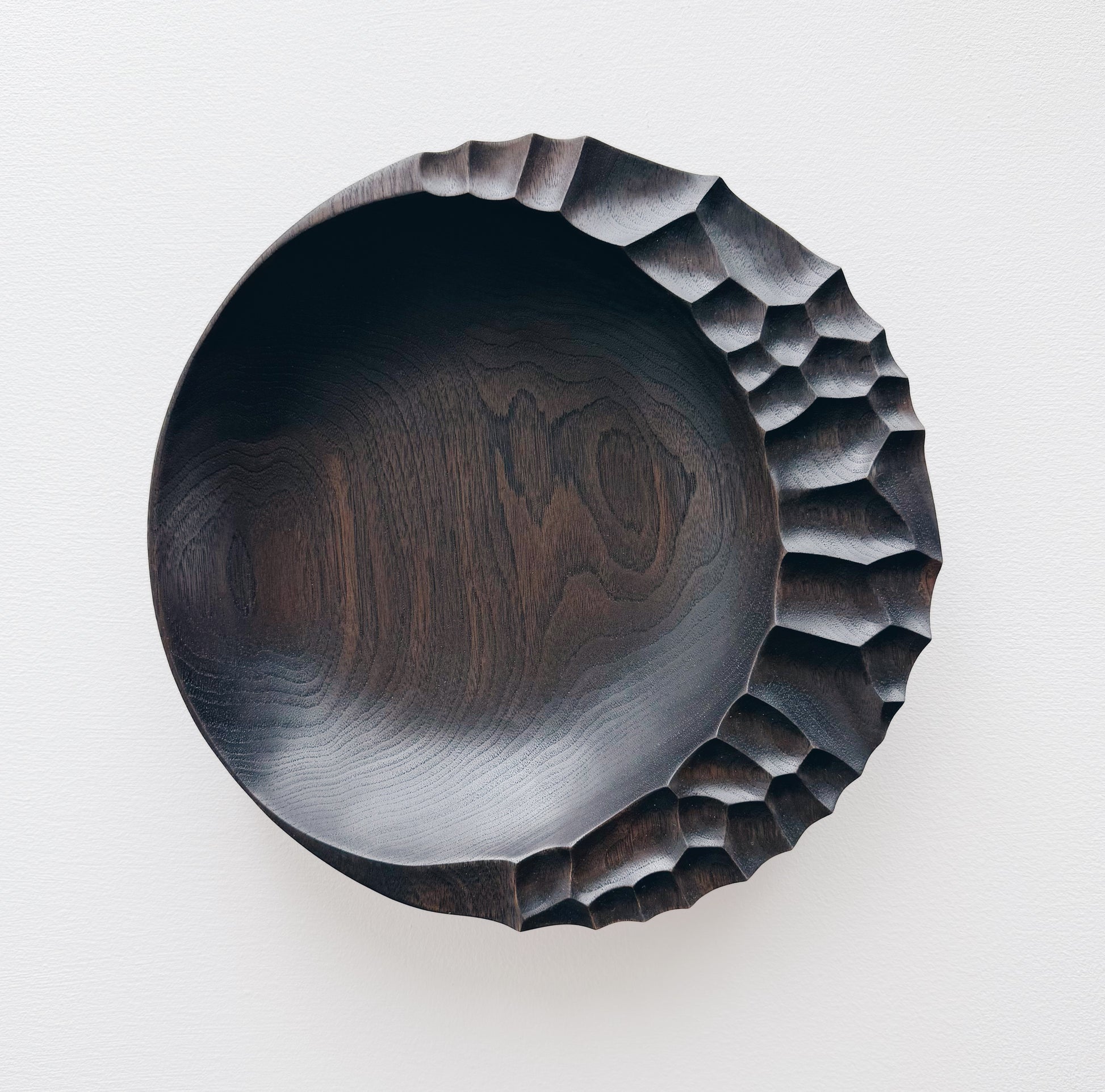 Ebonised walnut presentation board with sculptural design on a white background