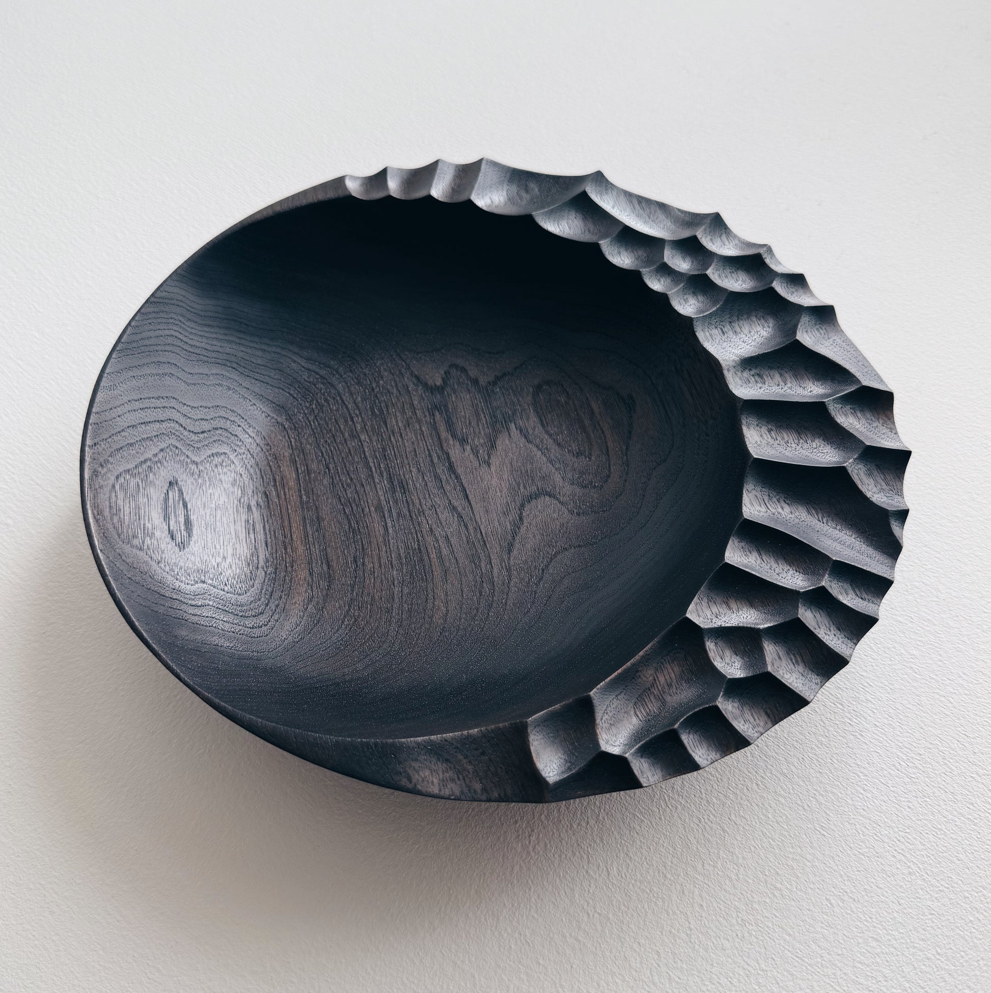 Ebonised walnut presentation board with sculptural design on a white background