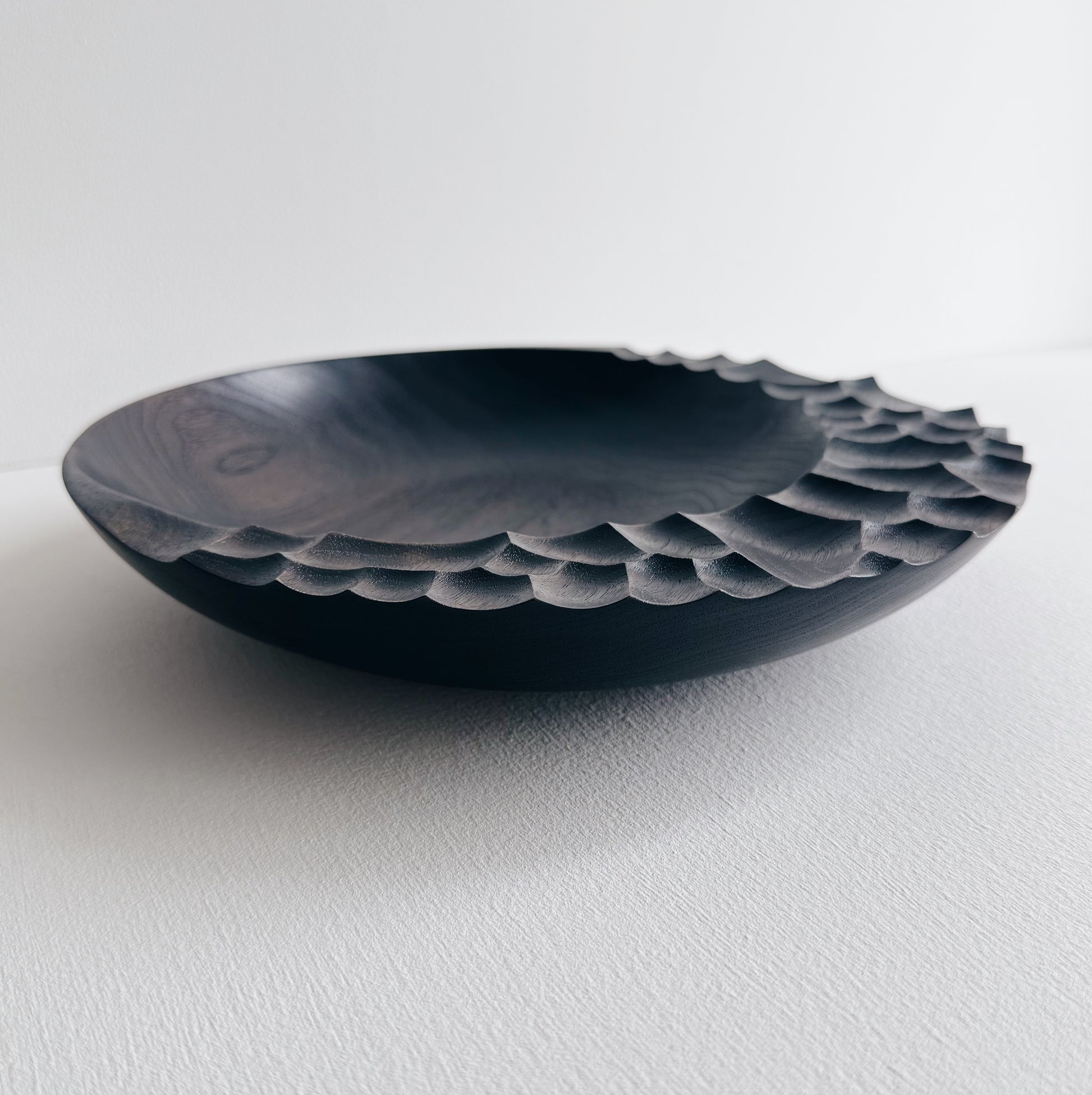Ebonised walnut presentation board with sculptural design on a white background