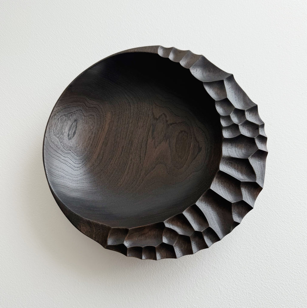 Ebonised walnut presentation board with sculptural design on a white background