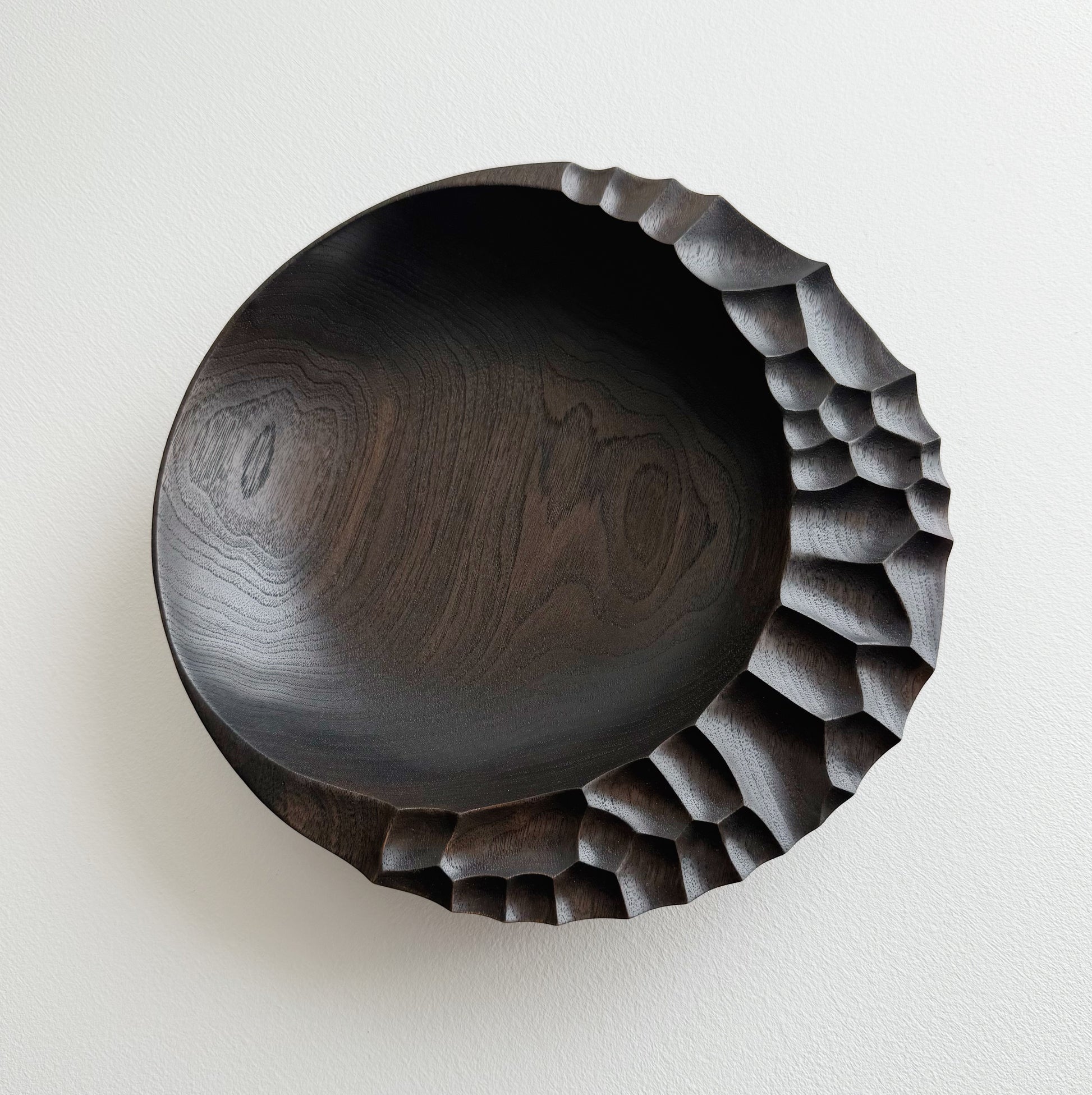 Ebonised walnut presentation board with sculptural design on a white background