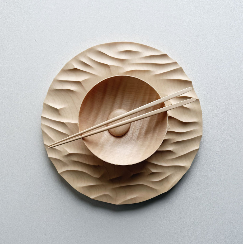 Large Gathered sycamore wooden plate with textured edge and bowl with chopsticks on a light background