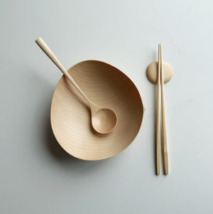 Sycamore oval bowl, angled eating spoon, wooden chopsticks and pebble rests on a white background
