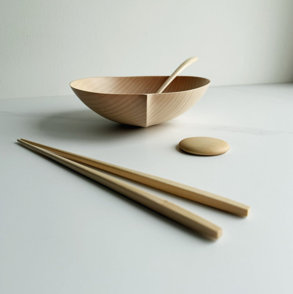 Sycamore oval bowl, angled eating spoon, wooden chopsticks and pebble rests on a white background

