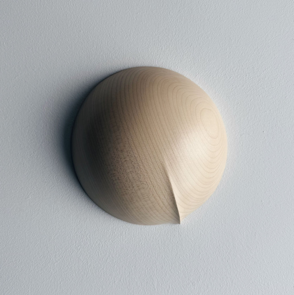 Upside down view of a round palm bowl in sycamore on a white background
