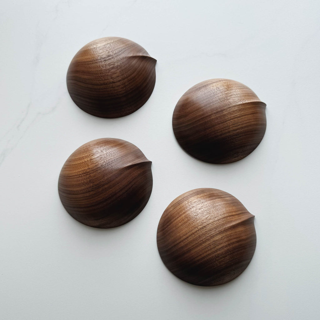 Four wooden bowls in walnut on a white background