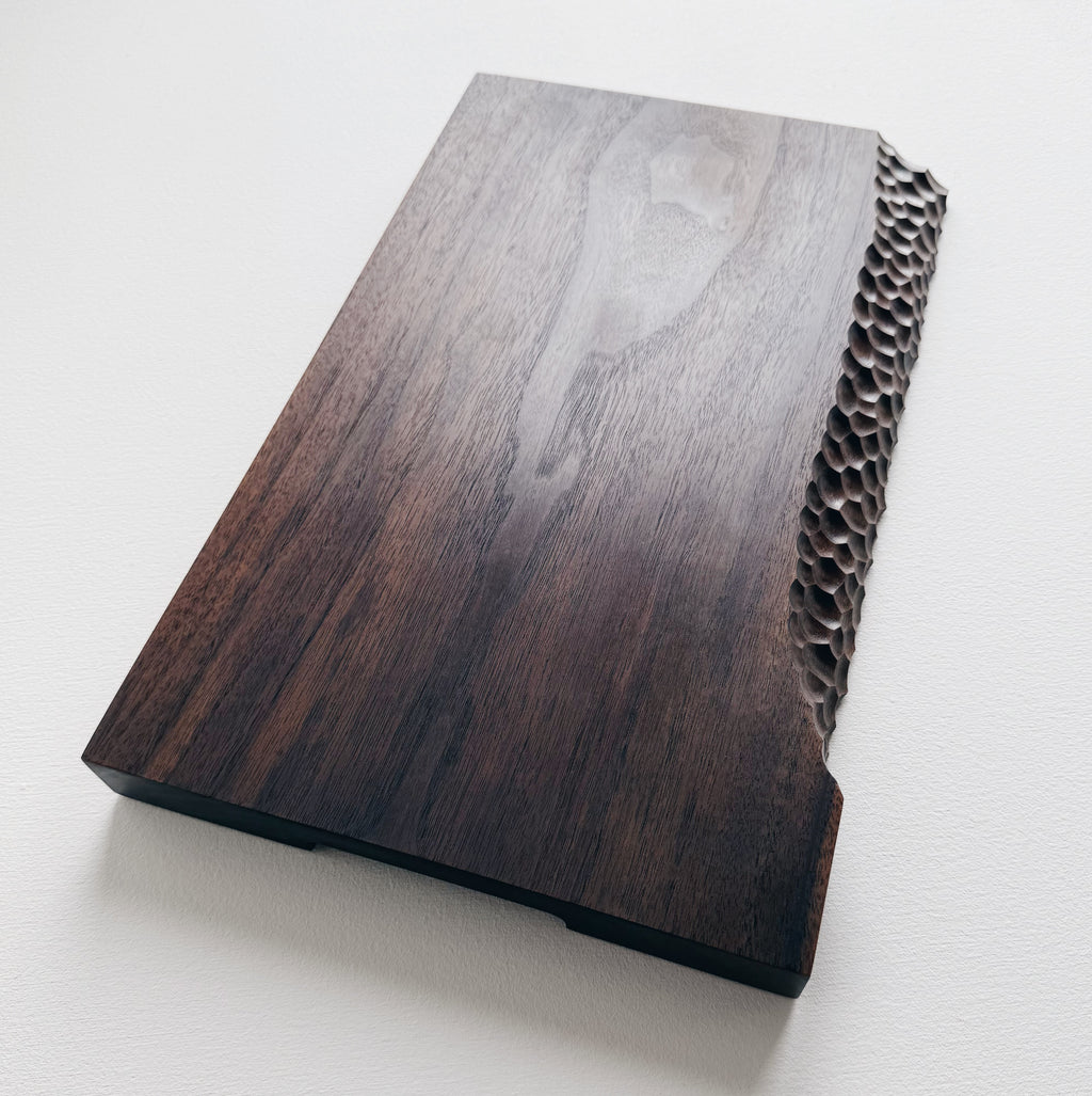 Black walnut presentation board with crater edge on a white background