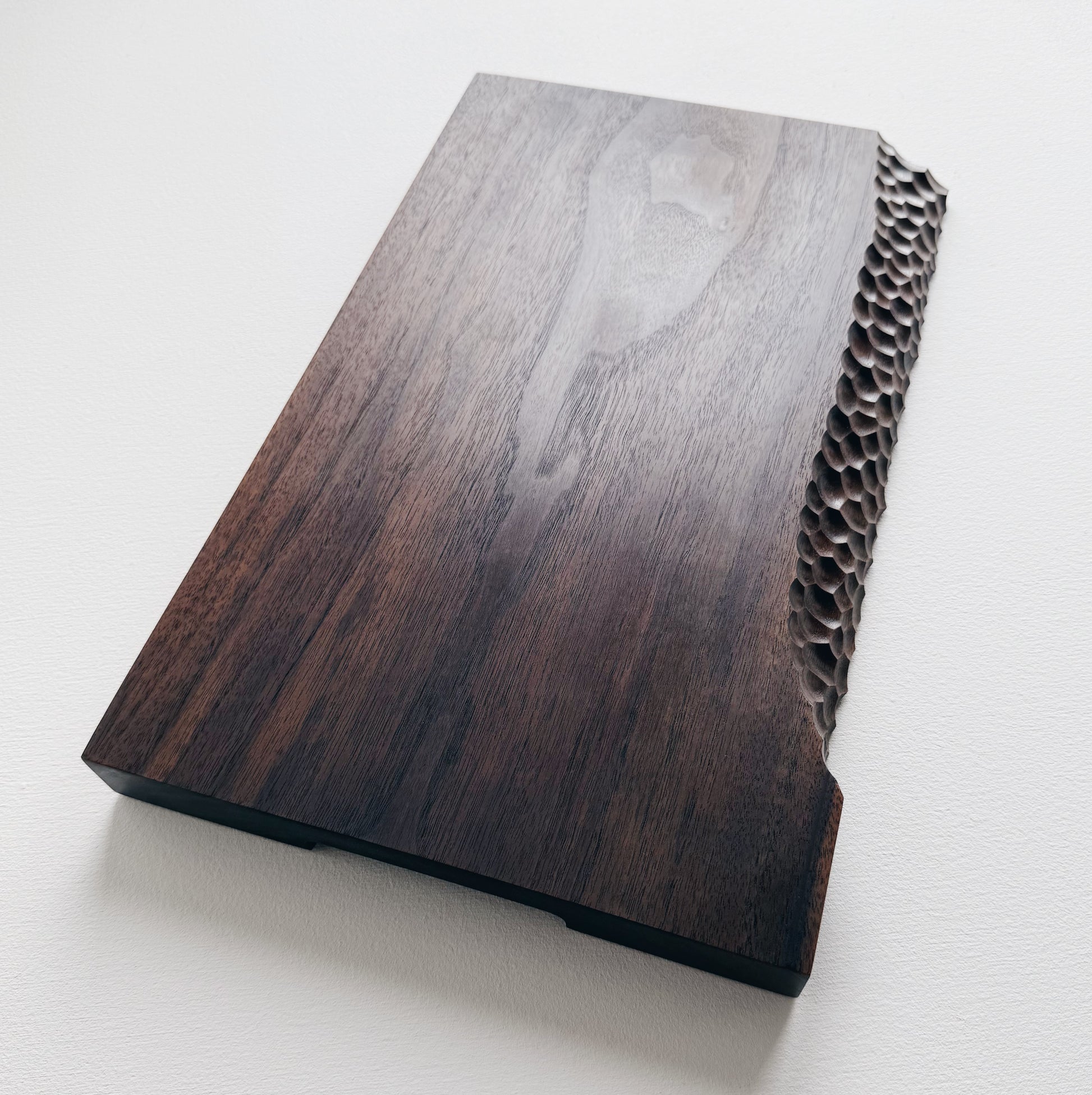 Black walnut presentation board with crater edge on a white background