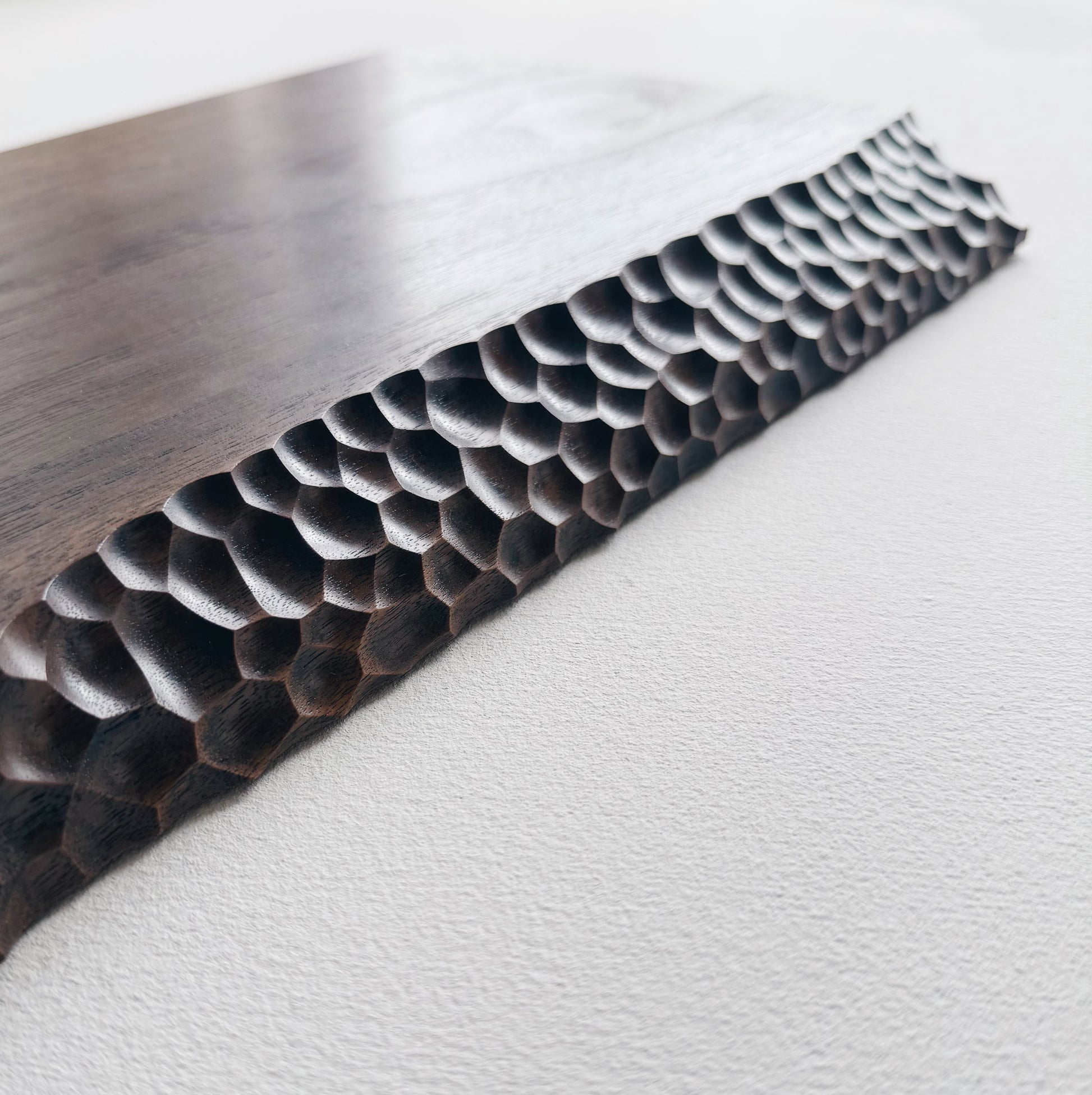 Close up of black walnut presentation board with crater edge on a white background