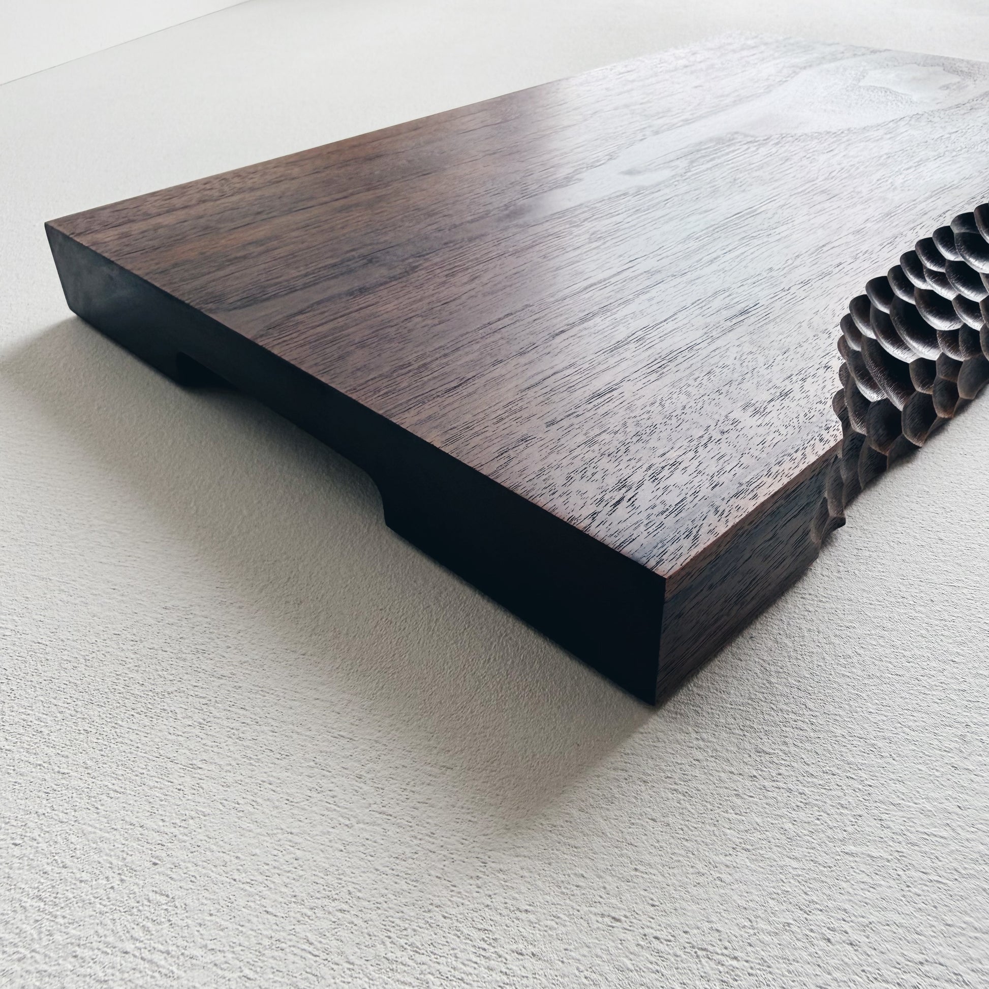 Close up of black walnut presentation board with crater edge on a white background