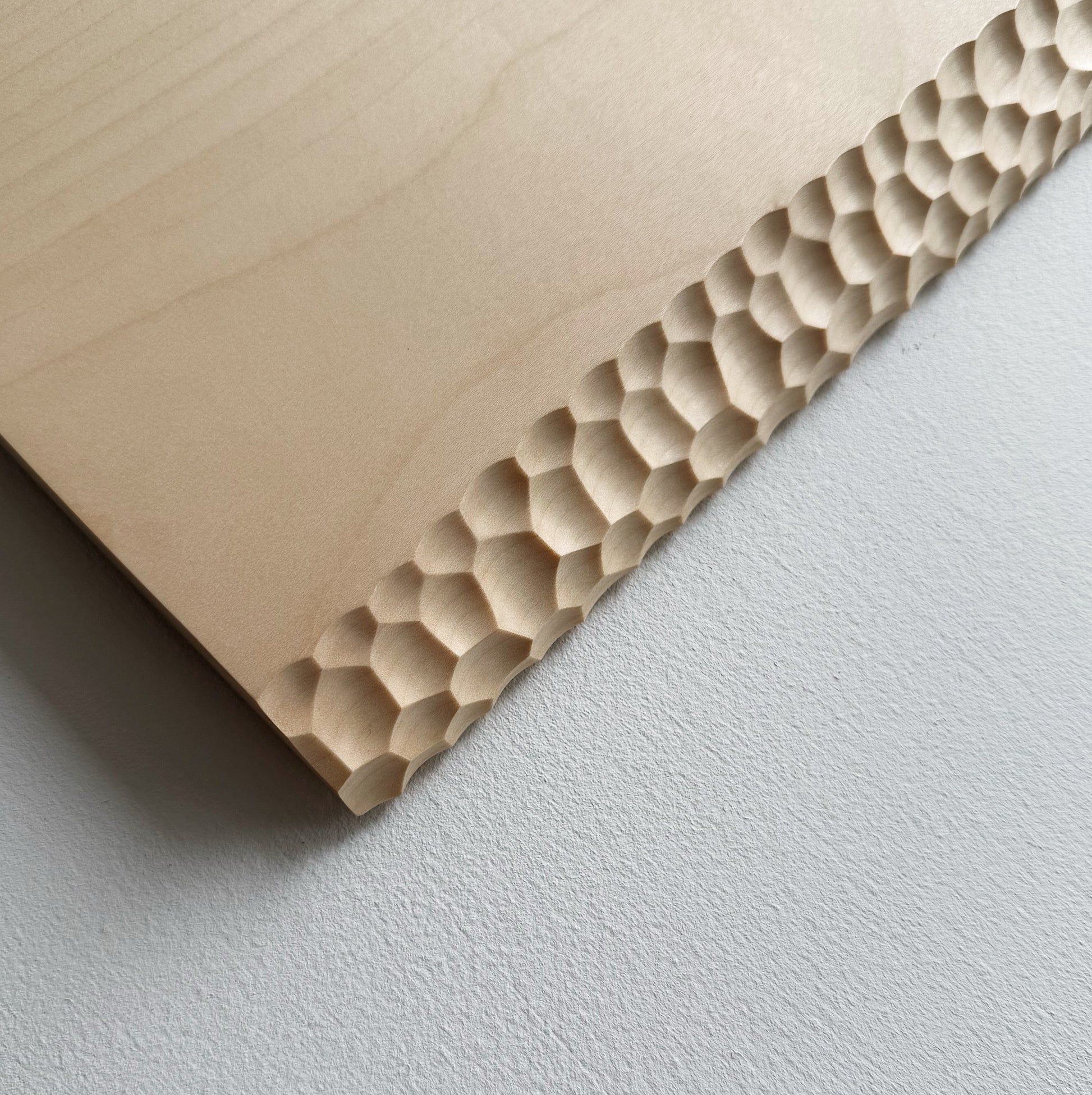 Close up of sycamore wooden presentation board with crater edge on a white background