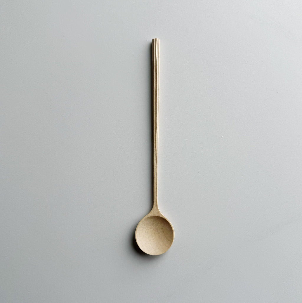 Sycamore spoon with sculpted handle on a light background
