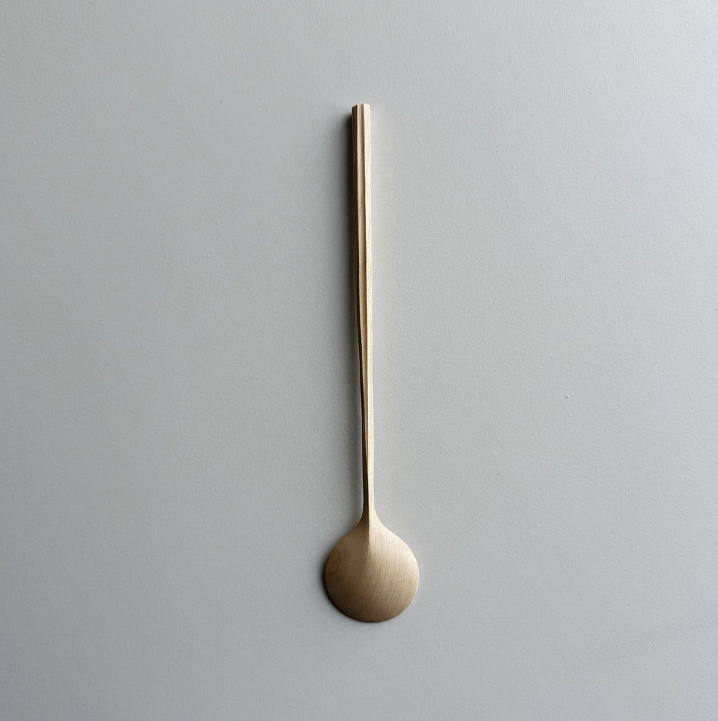 Sycamore spoon with sculpted handle on a light background

