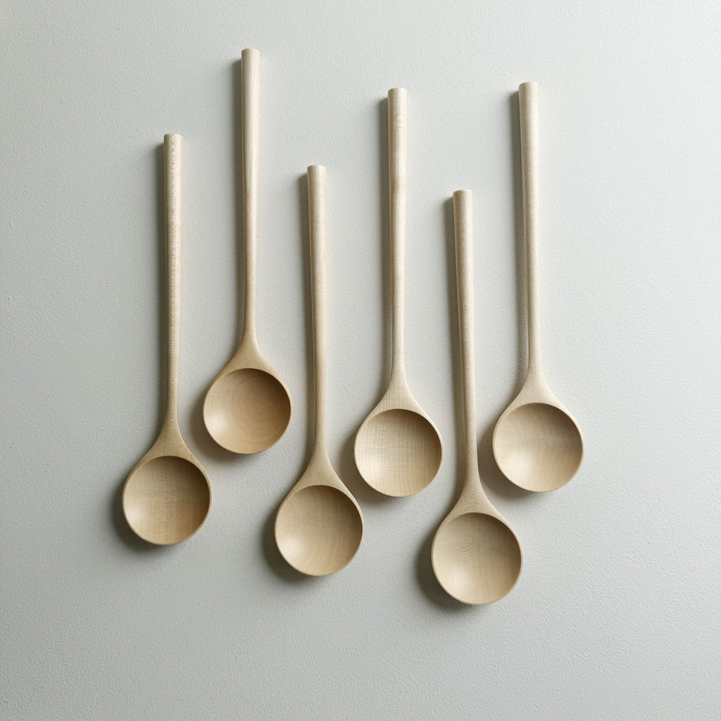 Set of six sycamore serving spoons on a light background