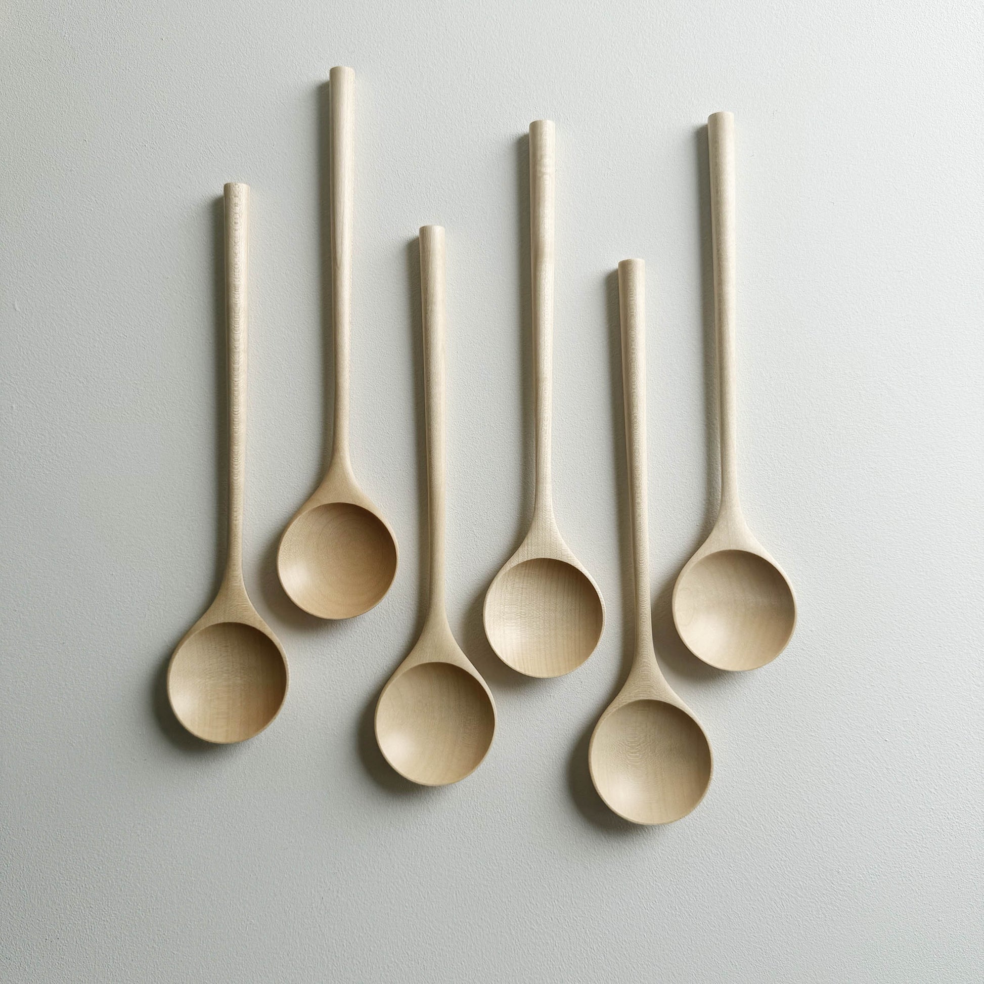 Set of six sycamore serving spoons on a light background