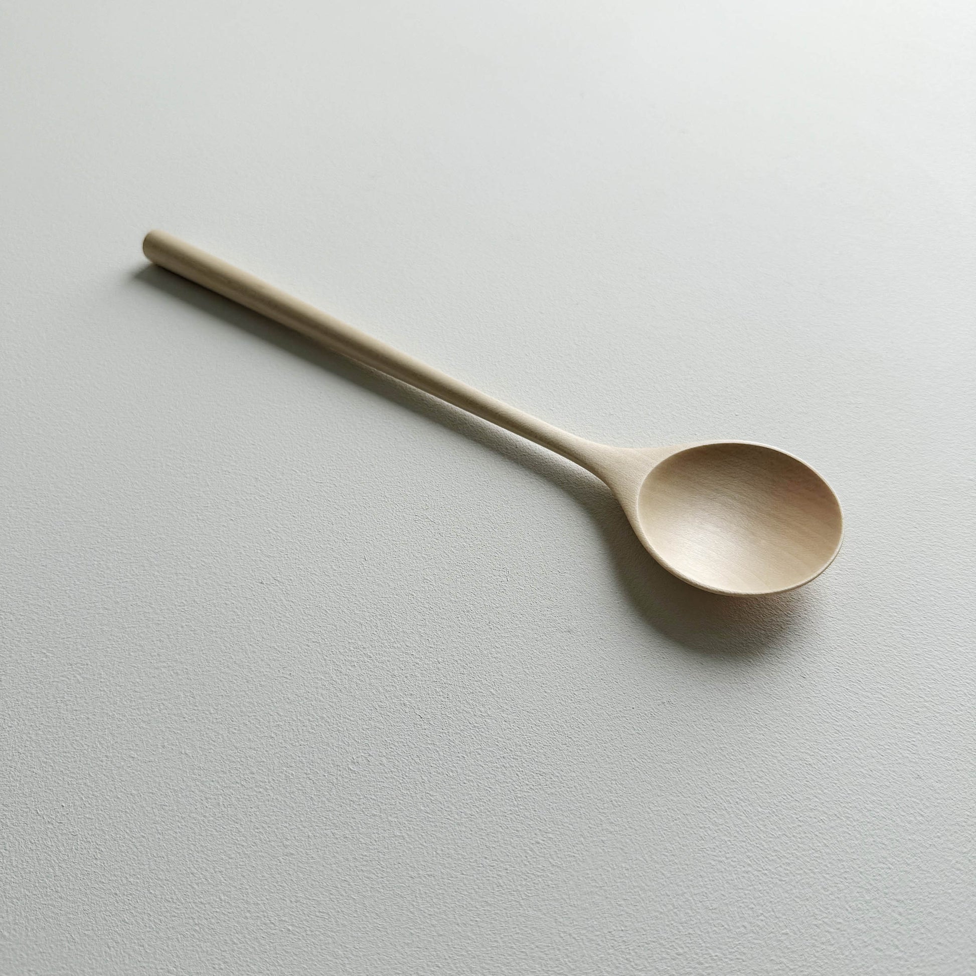 Sycamore serving spoon on a light background
