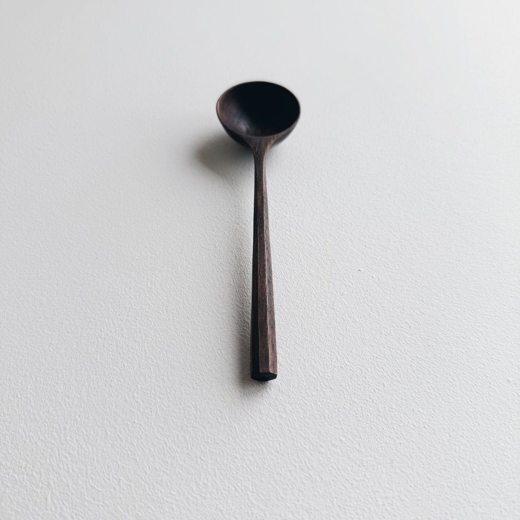 Black walnut wooden scoop on a white background
