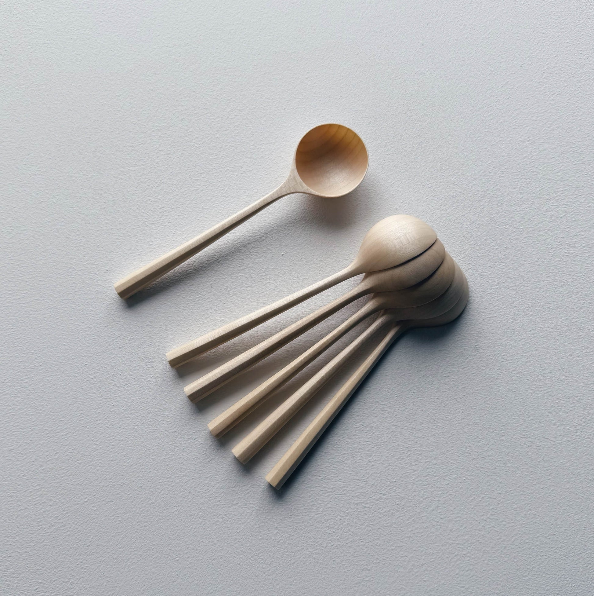 Set of sycamore wooden scoops on a white background